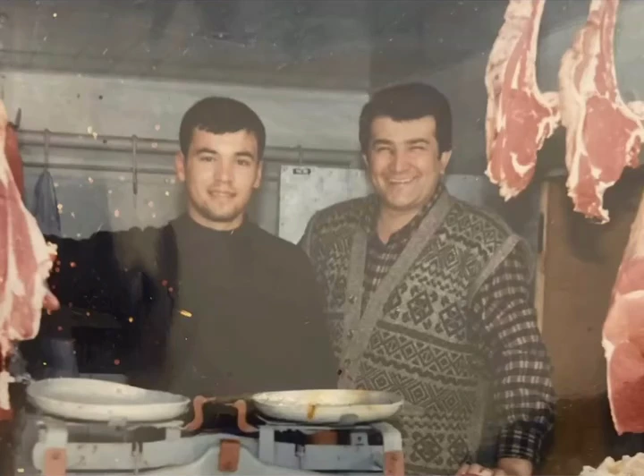 An older photograph of two butchers standing behind their counter